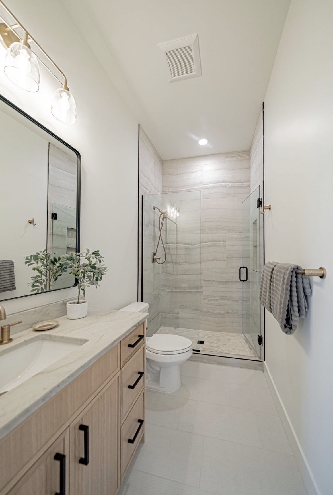 Primary bath vanity running toward a glass shower